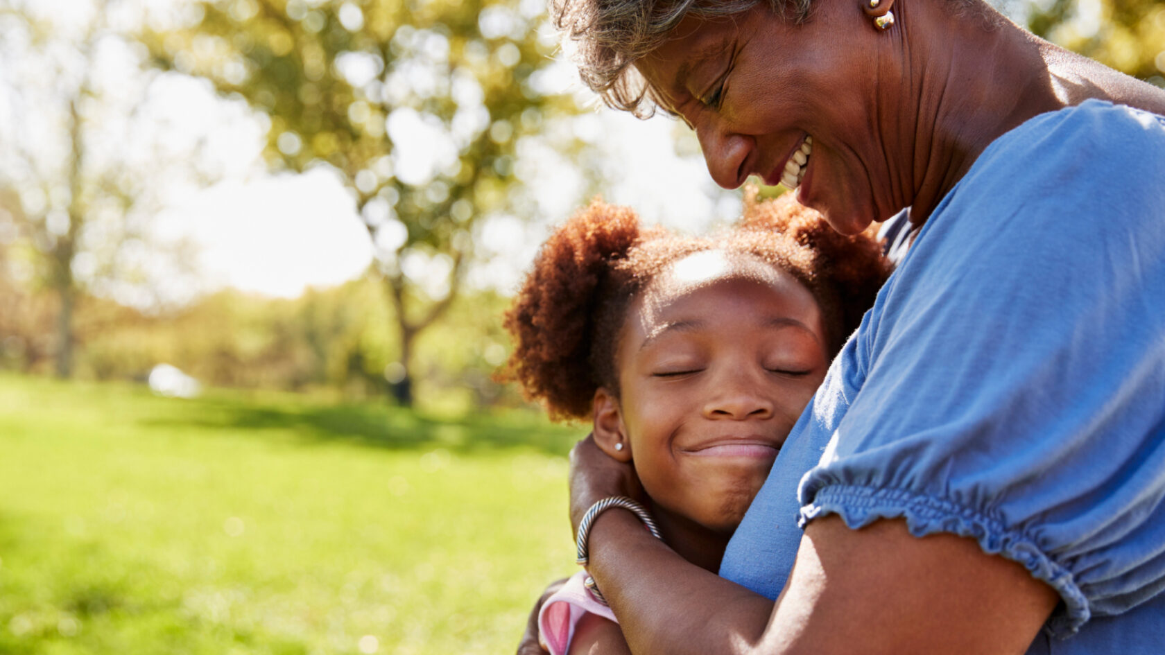 A grandmother hugs her granddaughter.