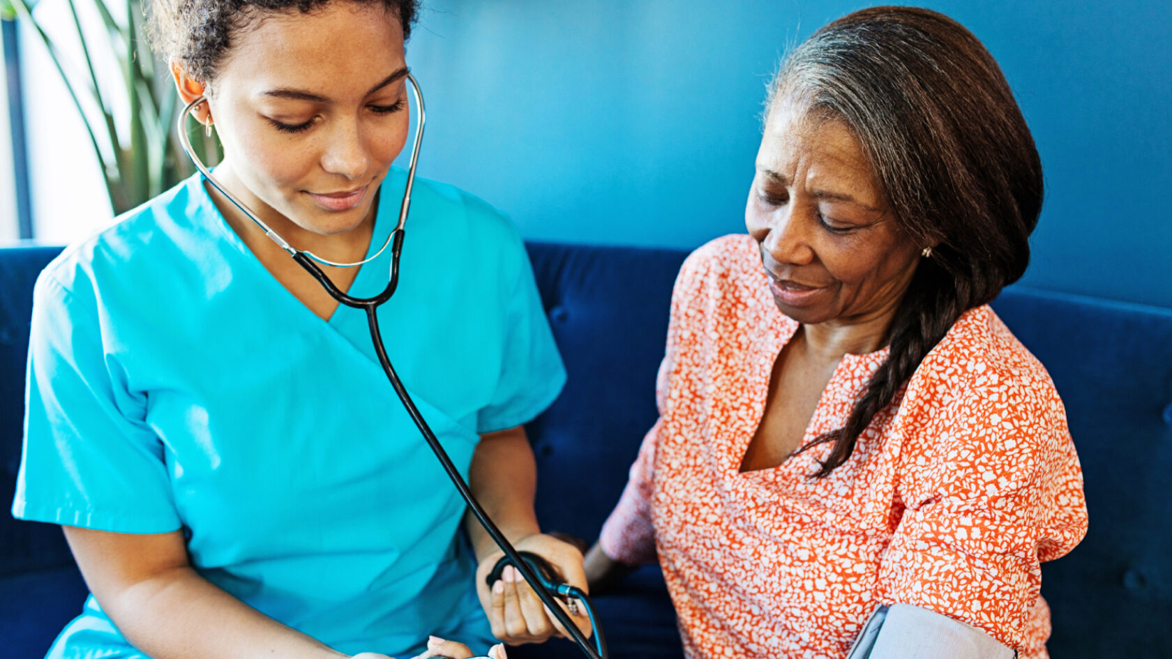 A clinician takes a woman’s blood pressure.