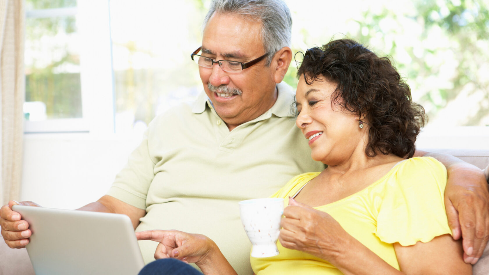 A husband and wife review information on a tablet.