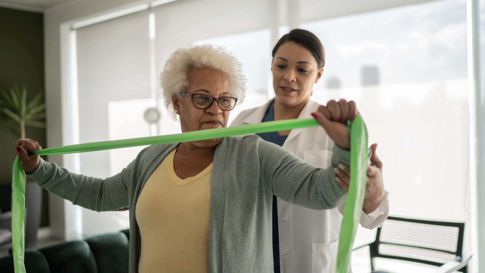 A clinician helps a woman with her exercise routine.