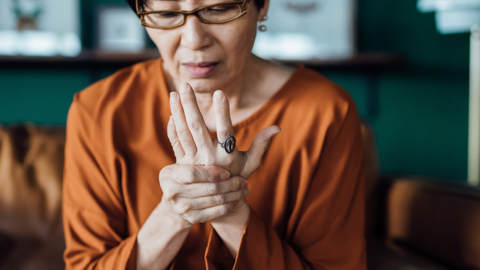 A woman rubs her hand in discomfort.