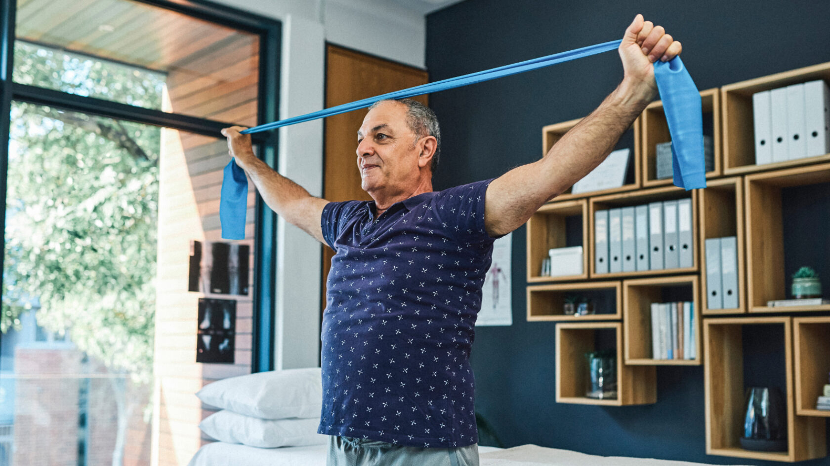 A man pulls an exercise band over his head.