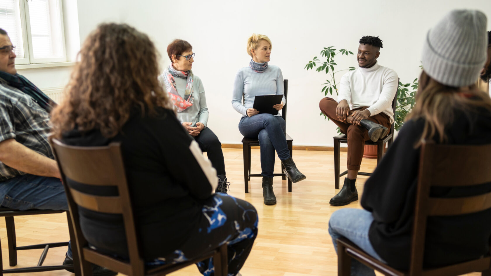 A support group meets in a well-lit room.