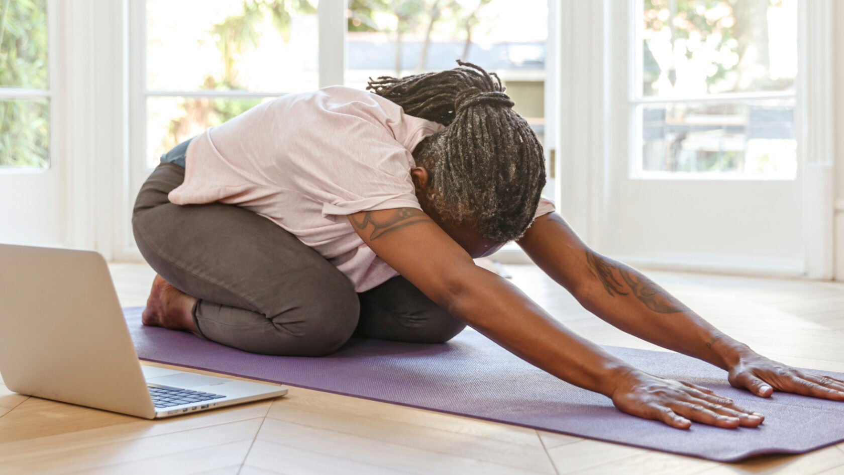 A woman stretches on a yoga mat.