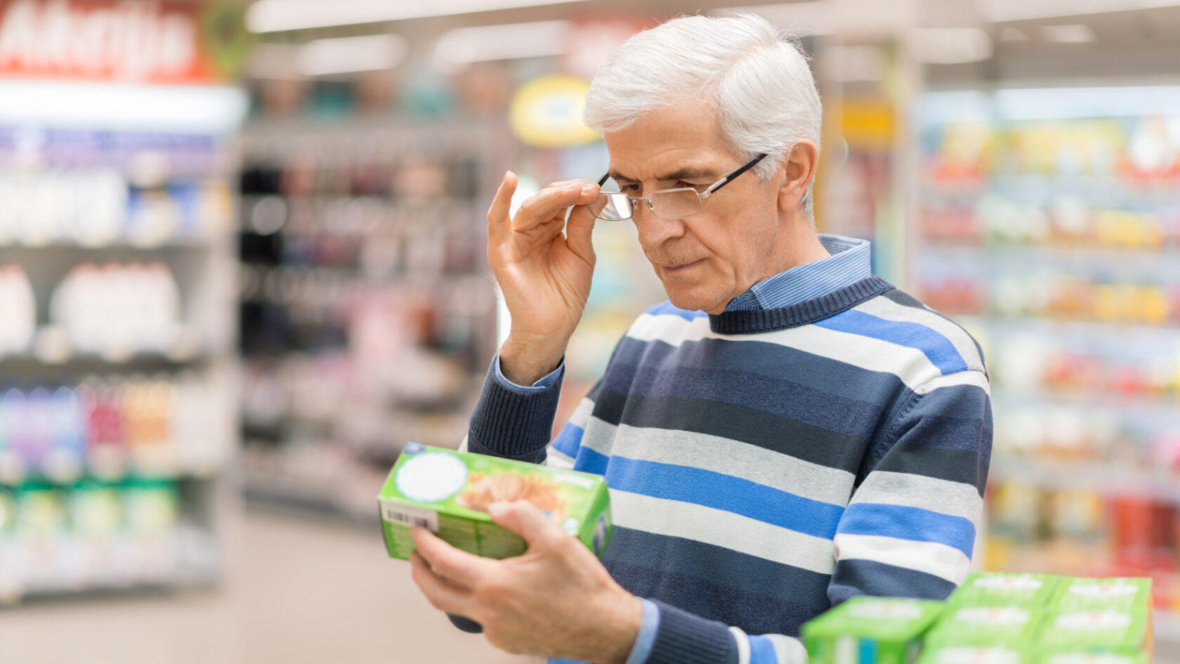 A man reviews the nutrition facts on a product in the supermarket.