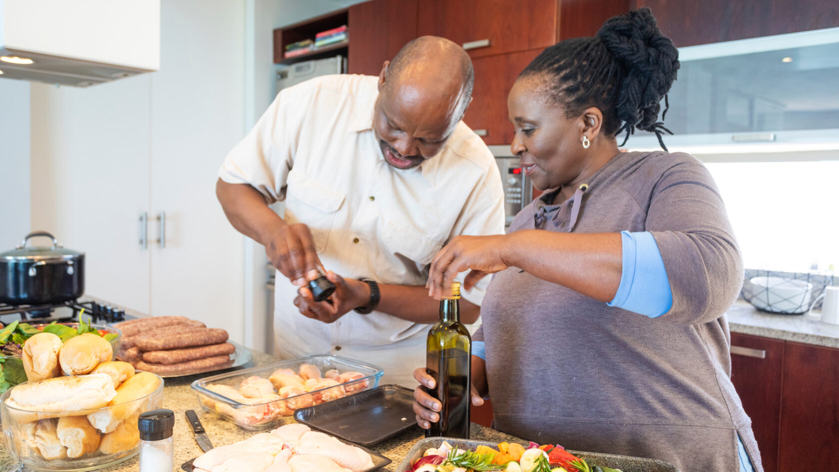 A man and woman make a meal in the kitchen.